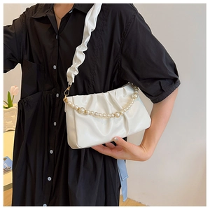 Détail d'un sac nuage blanc avec chaîne en perles et bandoulière large plissée chic