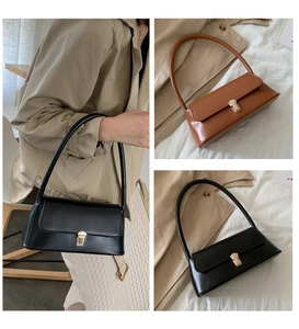 Detail view of vintage baguette bag with gold metal buckle closure and leather texture