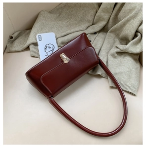 Detail of burgundy baguette bag on beige sofa showing interior capacity for a smartphone
