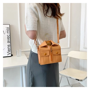 Detail of jacket-shaped mini crossbody bag with golden hanger handle on a female model