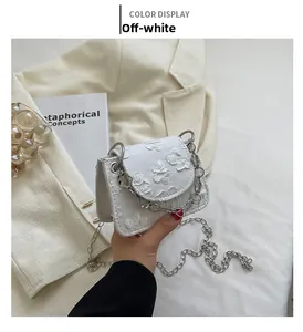 Detail of beige jacquard mini round bag with 3D floral texture and silver chain strap