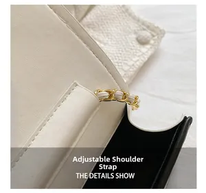 Detail of adjustable chain strap with woven gold metal and white leather for crossbody bag