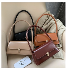 Multiple vintage baguette bags in black, beige, tan and burgundy on a beige sofa
