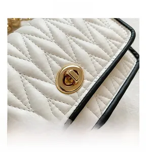 Close-up of beige quilted leather crossbody bag with golden oval turn-lock closure