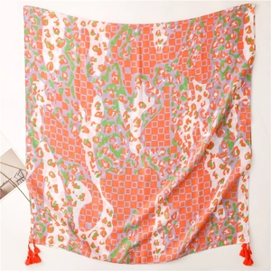 Detail of soft scarf with orange tassels, geometric grids and green leopard patterns