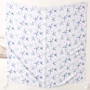 Detail of star-patterned cotton-linen scarf featuring white tassels and ocean motifs