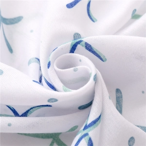 Detail shot of soft cotton floral scarf fabric showing light texture and blue patterns