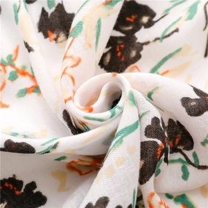 Gros plan sur l'écharpe blanche aux motifs floraux et texture douce en coton et lin