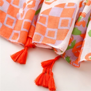 Close-up of orange and purple checkered scarf with bright fringe and woven texture