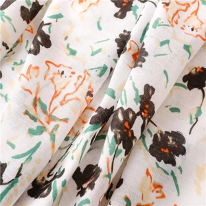 Gros plan du motif floral à l'encre sur tissu d'écharpe en coton-lin doux au toucher