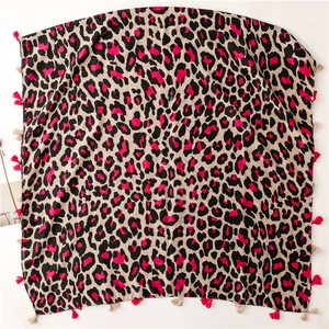 Detail view of bold leopard print scarf with pink fringe and soft texture