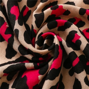 Macro detail of leopard print scarf fabric with bold pink and brown patterns