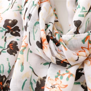 Détail d'une écharpe légère à fleurs avec motifs botaniques orange et texture douce