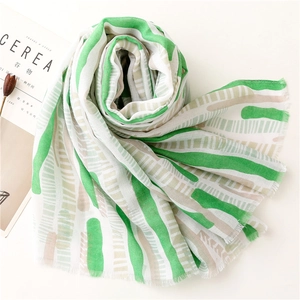 Detail of mint green striped summer scarf with fine fringe edges and soft texture