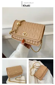 Detail of khaki quilted chain bag featuring a gold twist lock and decorative gold bead
