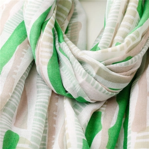 Detailed texture of lightweight mint green scarf with abstract geometric print patterns