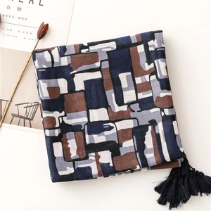Detail of geometric pattern scarf with navy tassels and soft linen texture