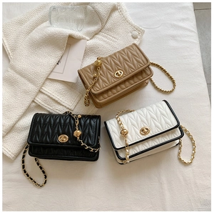 Three V-quilted handbags in tan, black and white with gold chain straps and ball adjusters