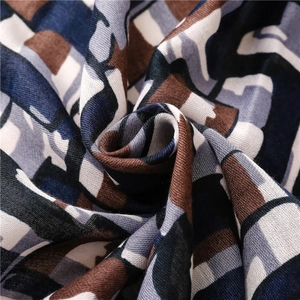 Detailed macro view showing the textured geometric weave and soft drape of this long scarf