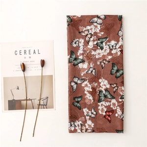 Détail du motif papillon ethnique sur foulard au toucher lin et imprimé floral vintage