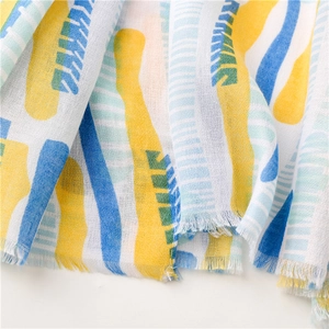 Close-up of lightweight chiffon scarf with colorful abstract prints and frayed edges