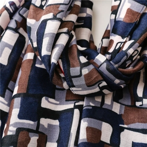 Detailed close-up of soft cotton-linen scarf showing abstract geometric block patterns