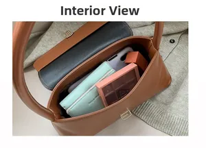 Internal view of brown leather bag showing daily essentials and metal clasp