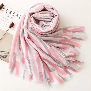 Detail of pink and gray striped summer scarf with fringe edges on white background