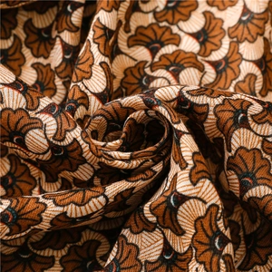 Détail macro du motif floral ginkgo sur un châle doux en coton et lin tissé