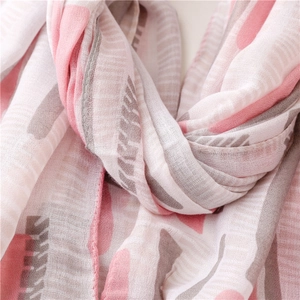 Detail of soft mint green and pink printed scarf fabric texture and frayed edges