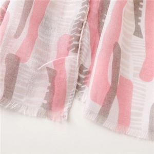 Detail of mint green summer shawl featuring abstract fish patterns and soft fringe edges