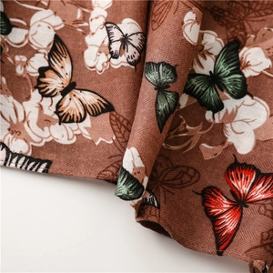 Gros plan d'une écharpe en coton et lin avec motif chevrons et imprimé papillon vintage