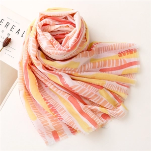 Detail of orange and yellow striped lightweight scarf with delicate tassel edges