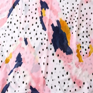 Gros plan sur le tissu du foulard à pois avec imprimé abstrait aquarelle rose et bleu