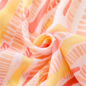 Detailed close-up of summer sun protection scarf with orange abstract striped print