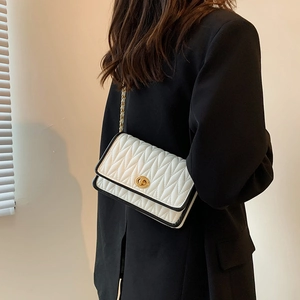 White quilted shoulder bag with black contrast piping and gold chain strap for women