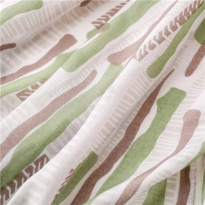 Macro view of mint green abstract print on lightweight breathable summer shawl fabric