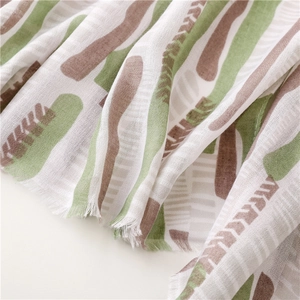 Detailed view of mint green and brown abstract patterned fabric with raw fringe edges