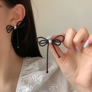 Elegant white crystal bow tassel earrings with black bead weave and pearl center