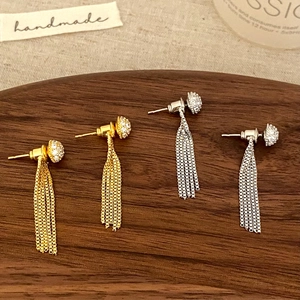 Boucles d'oreilles élégantes à franges en or et argent avec strass sur plateau bois