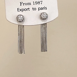 Gros plan sur des boucles d'oreilles à pompons argentés avec clous en zircon étincelants