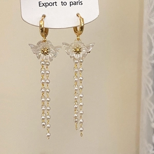 Elegant floral pearl tassel earrings with gold hoop details on jewelry display card