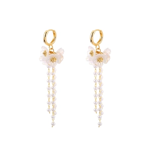 Elegant flower earrings with long pearl tassels and gold round hoop on white backdrop