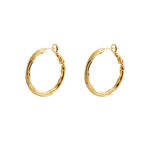 Minimalist textured golden hoop earrings with irregular hammered finish and wave design