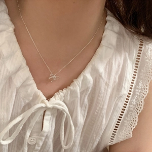 Elegant silver bow pendant necklace with minimalist thin chain shown on a female model
