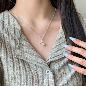 Minimalist silver chain necklace with an artistic irregular pendant and pearl accents