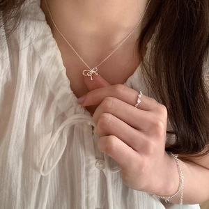 Elegant silver bow pendant necklace for women on a model with minimalist Korean style
