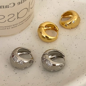Detail of gold and silver thick hoop earrings with micro-set zircon starburst engraving
