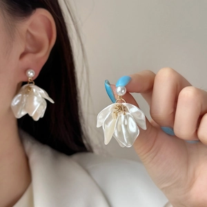 Elegant white pearl flower petal earrings with gold alloy details on model