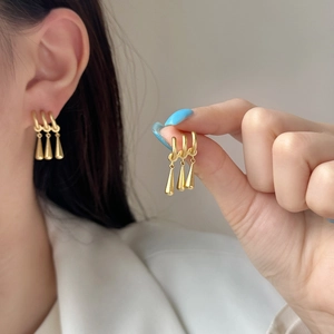 Élégantes boucles d'oreilles franges plaquées or avec pendentifs gouttes sur mannequin
